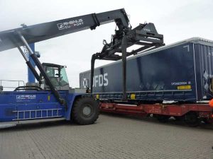 Foto: Umschlag eines Containers vom Zug auf das Terminal mit direktem Gleisanschluss. Bildquelle: Cuxport GmbH