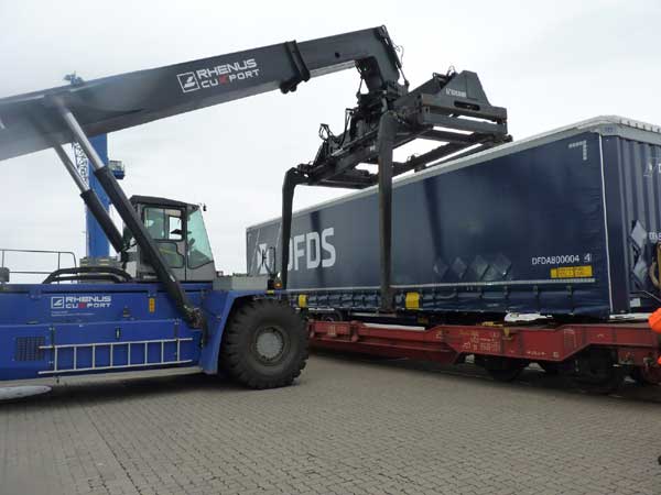 Foto: Umschlag eines Containers vom Zug auf das Terminal mit direktem Gleisanschluss. Bildquelle: Cuxport GmbH